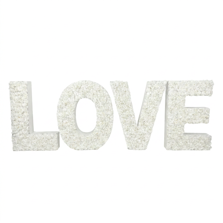 Grandes lettres "LOVE" blanches décorées de fleurs, posées au sol pour décoration d’événement