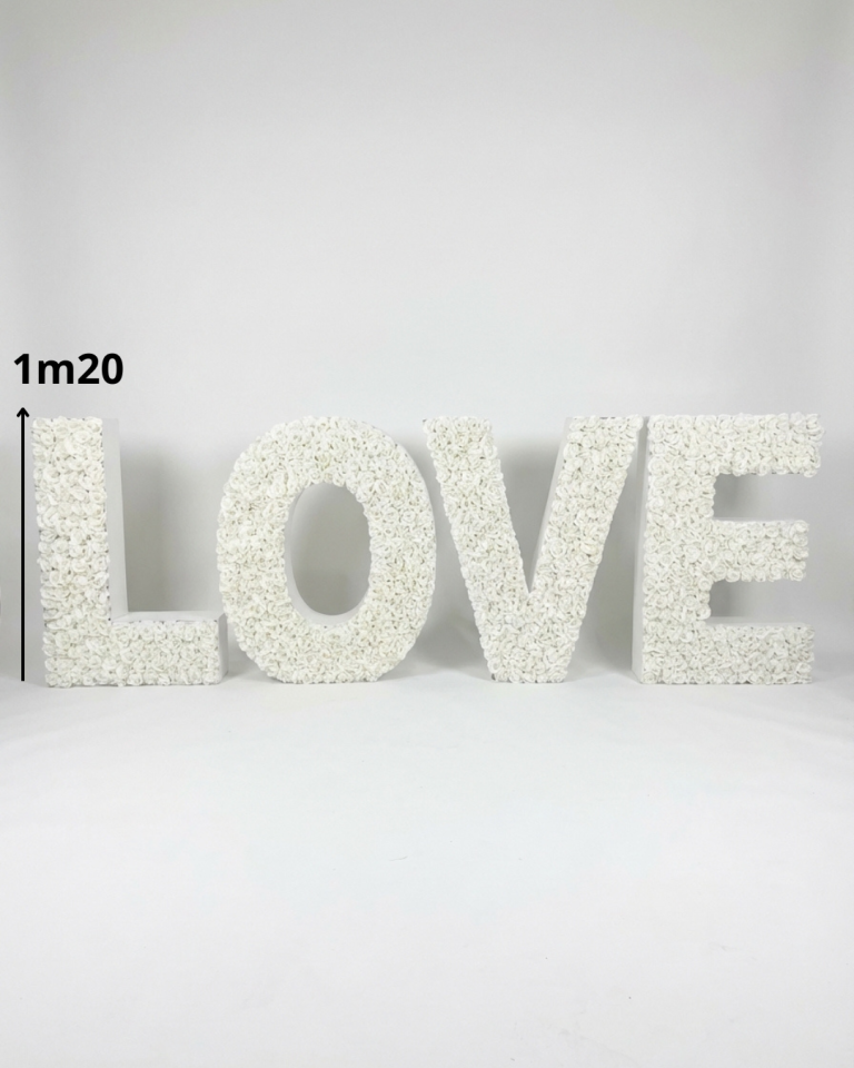Grandes lettres "LOVE" blanches décorées de fleurs, posées au sol pour décoration d’événement
